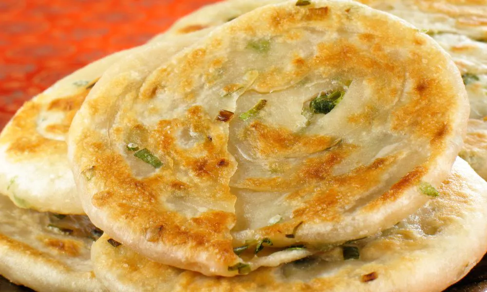 Stack of pan-fried scallion pancakes with crispy golden edges at Mingxia Dumpling, a Chinese Restaurant in Cordova